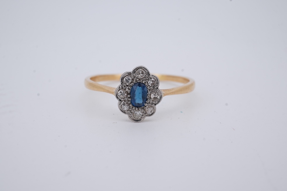 A 1920's yellow metal, stamped 18ct, sapphire and diamond set oval cluster ring, size V, gross weight 2.3 grams. Condition - poor to fair